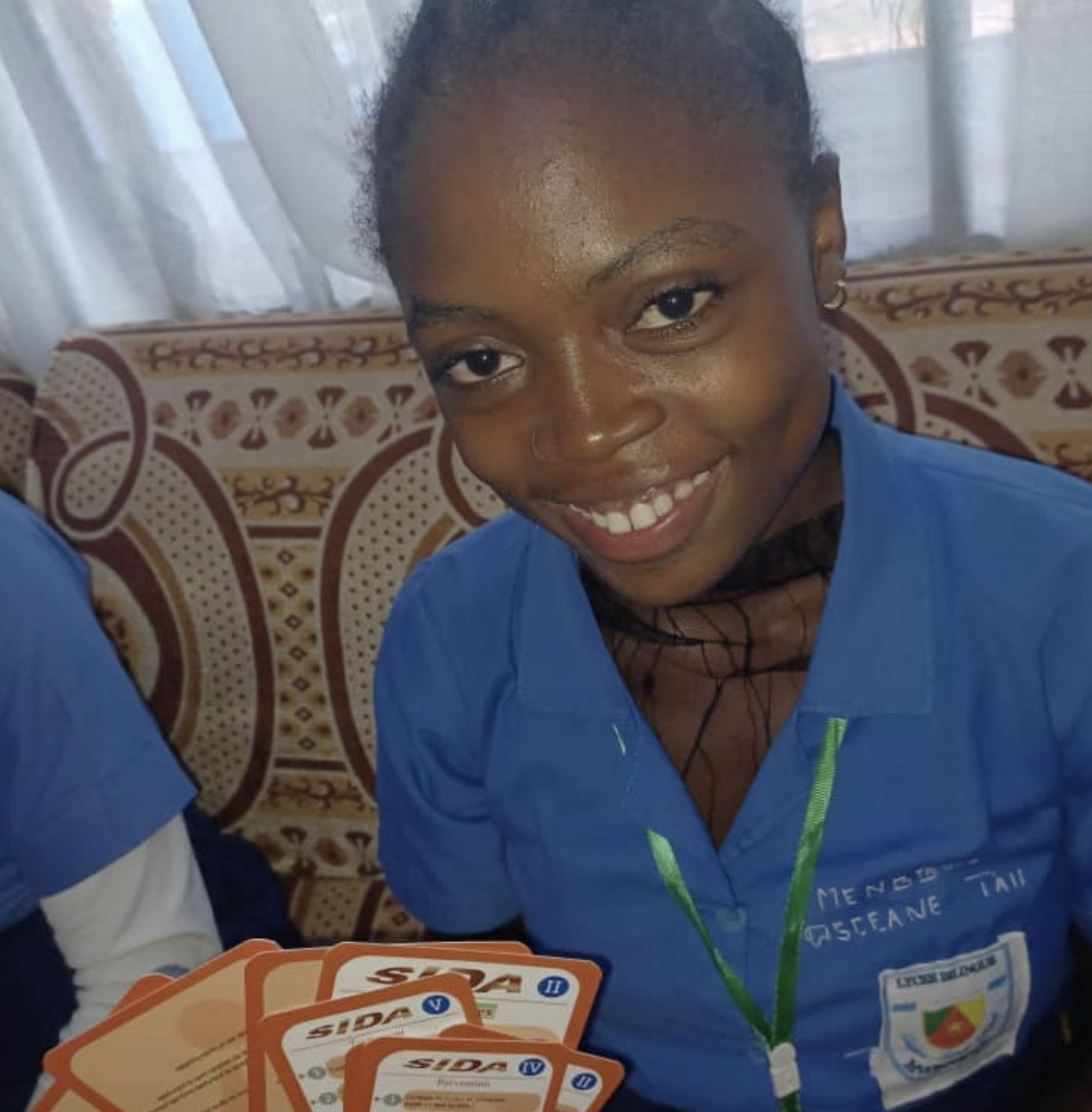 Élève tenant les cartes Carie dentaire et Paludisme